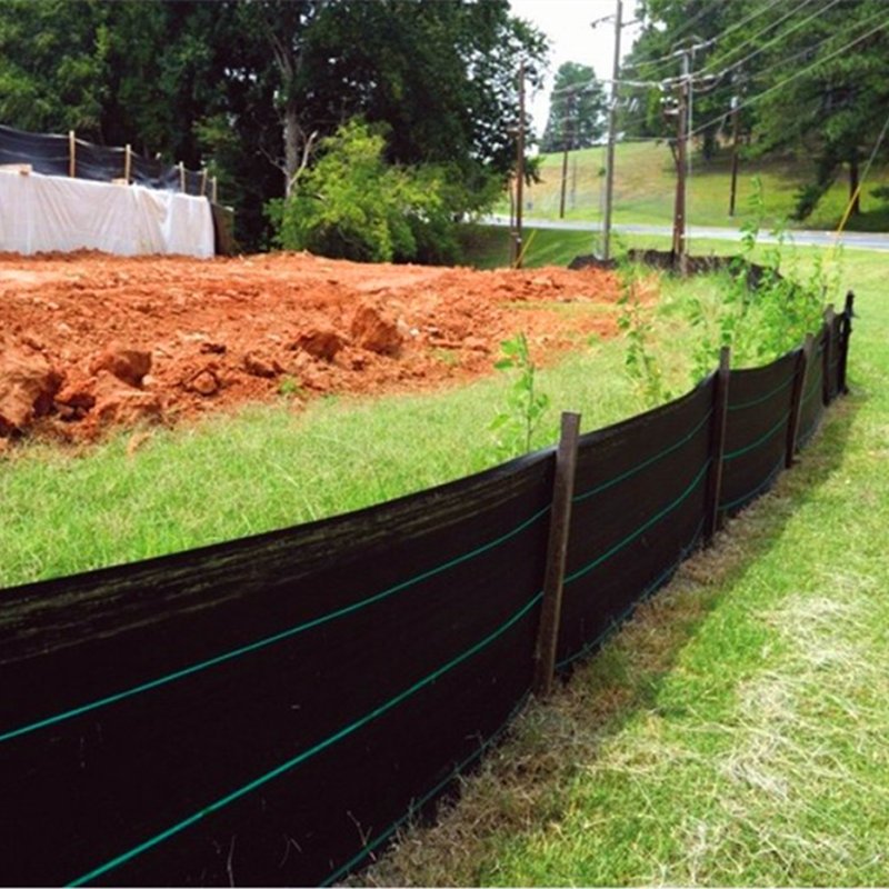 Black woven fabric used as farm fencing and windbreak barrier